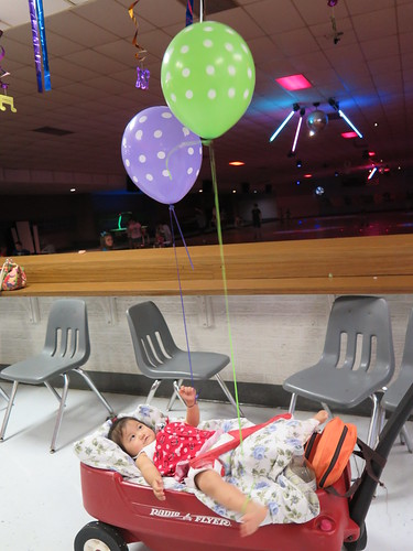 Dani in her wagon playing with balloons.